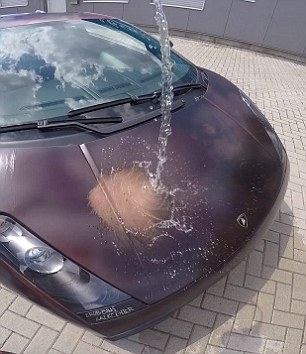 A German artist has released a video of a Lamborghini (pictured) supercar magically changing colour after a splash of warm water to reveal a hidden Captain America design underneath using heat-sensitive paint